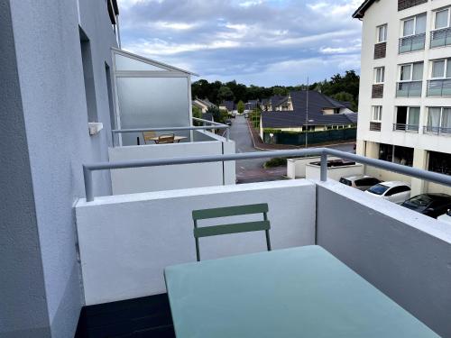 a white bench on the balcony of a building at Très bel appartement T2 de standing entièrement meublé à 5 min à pied du centre. in Divonne-les-Bains