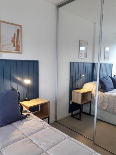 1 dormitorio con cama, escritorio y espejo en Austral 503 en Ushuaia