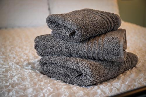 una pila de toallas sentadas en una cama en Great Glen Way Canal Side Apartment, en Inverness