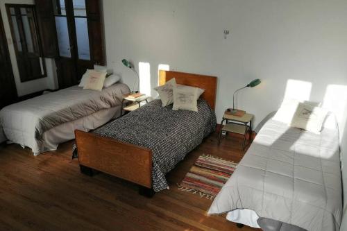 um quarto com 2 camas, uma mesa e um candeeiro em CASONA DE LORETO - alquiler temporario- em Azul