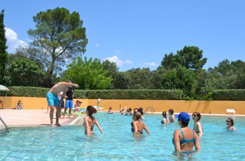 um grupo de pessoas brincando em uma piscina em Camping la Sousta**** em Remoulins