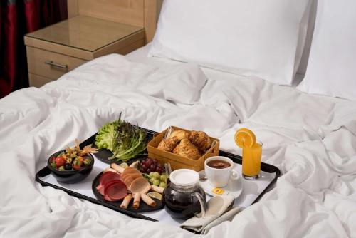 a tray of food on top of a bed at SAS Residence & Hotel Dhahran in Al Khobar