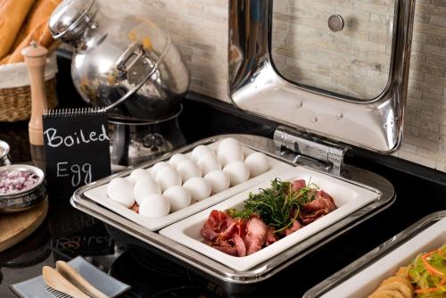 a tray of food with eggs and meat on a counter at SAS Residence & Hotel Dhahran in Al Khobar