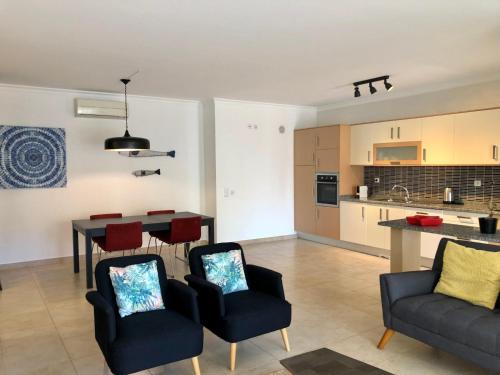 a living room with a table and chairs and a kitchen at Âncora Boutique Apartments in Lagos