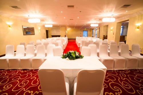 a banquet hall with white chairs and a table with flowers at London Croydon Aerodrome Hotel, BW Signature Collection in Croydon