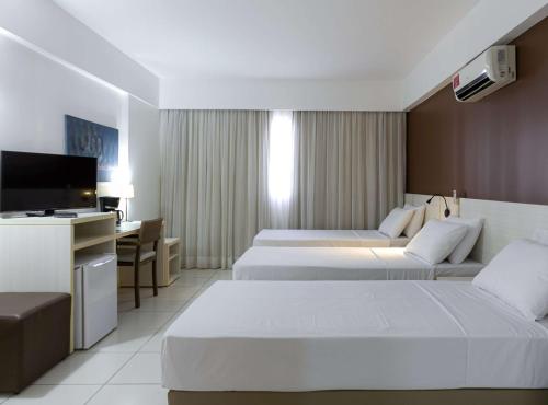 Cama ou camas em um quarto em Best Western Suites Le Jardin Caldas Novas