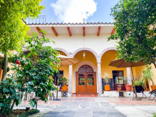 a yellow house with a wooden door and trees at Casa aroma de café, en el corazón de Coatepec. in Coatepec