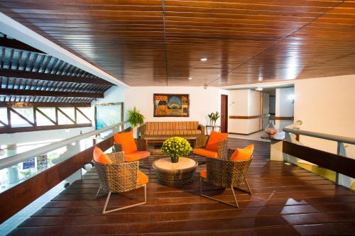 a living room with orange chairs and a couch at Monte Pascoal Praia Hotel in Porto Seguro