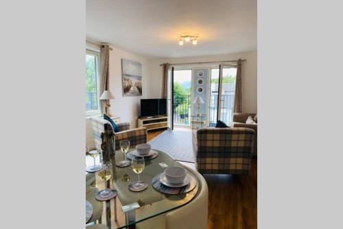 a living room with a table and a couch at Riverside View Apartment in Balloch, Loch Lomond in Balloch