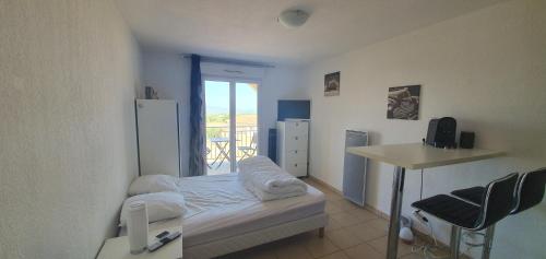 a small room with a bed and a table and a kitchen at Studio Vue Mer Circuit Paul Ricard - Domaine Securisé in Signes