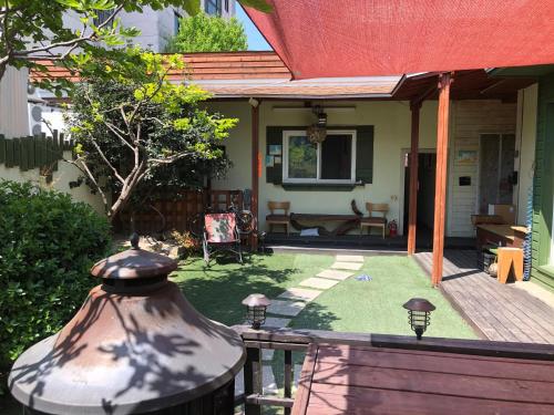 a house with a yard with a fence and a patio at Gyeongju Momojane Guesthouse in Gyeongju