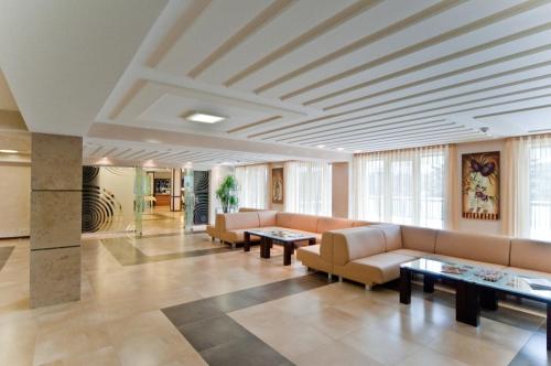 eine Lobby mit Sofas und Tischen in einem Gebäude in der Unterkunft Grand-Marine Hotel & SPA in Odessa
