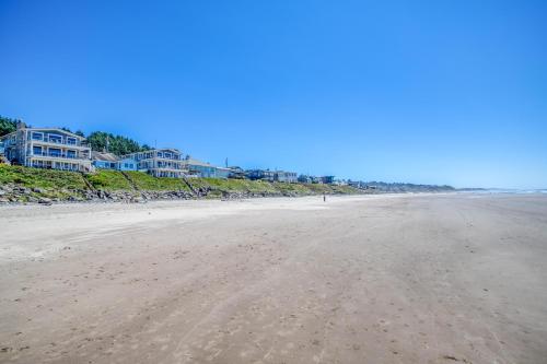 an empty beach with houses in the background at Captain Johns in Lincoln City