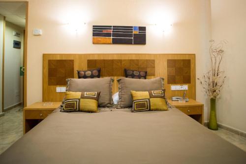 a bedroom with a large bed with yellow pillows at Hostal Azul in El Molar
