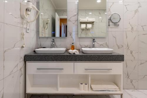 a bathroom with two sinks and a mirror at PARADISE Resort Hotel in Yuzhno-Sakhalinsk