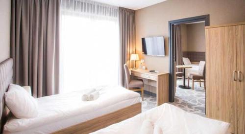 a hotel room with a bed and a desk and a window at Hotel Rondo in Wąbrzeźno