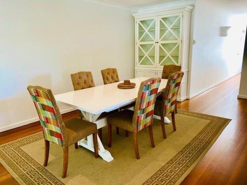 a dining room with a white table and chairs at BeachView Apartments at Villa Paradiso in Palm Cove