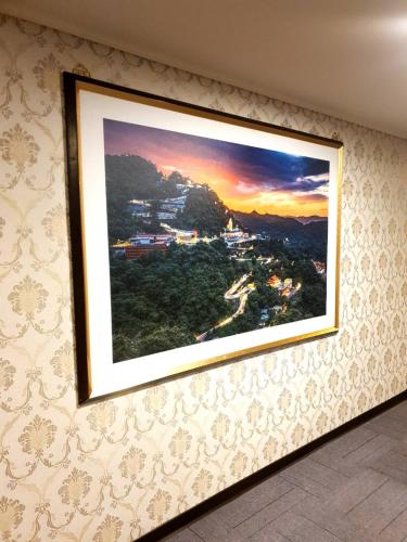 a painting hanging on a wall in a room at Chuan Fu Hotel in Fengyuan