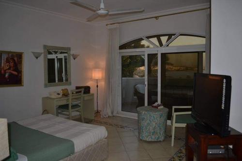 a bedroom with a bed and a desk and a television at قصر 2 in Sharm El Sheikh