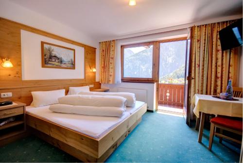 a bedroom with two beds and a large window at Roasnerhof in Finkenberg