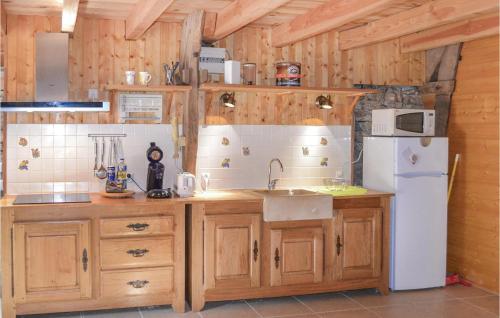 a kitchen with wooden cabinets and a white refrigerator at Awesome Home In Padirac With Wifi in Padirac