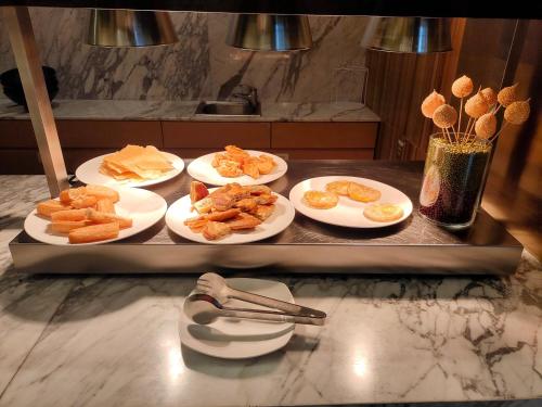 a tray with four plates of food on a counter at Skytel Hotel Chengdu-City Center in Chengdu