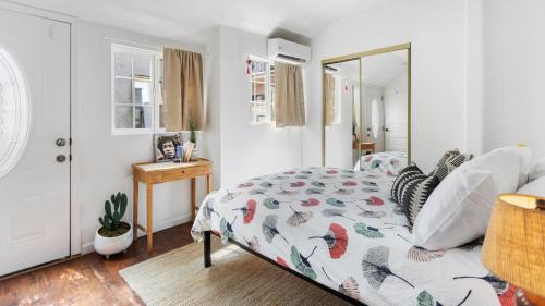 una camera da letto con un letto con un piumone e uno specchio di 4BR Bungalow in Echo Park a Los Angeles