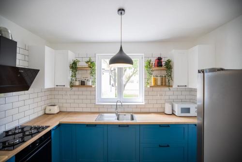 a kitchen with blue cabinets and a sink and a window at 1oak villa in Vir