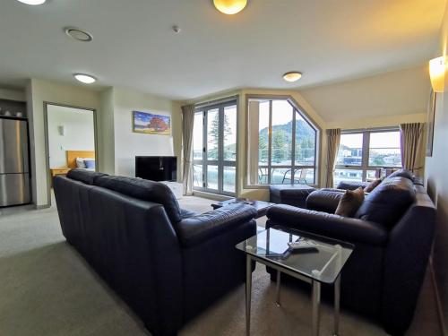 a living room with two couches and a table at The Anchorage Apartments in Mount Maunganui