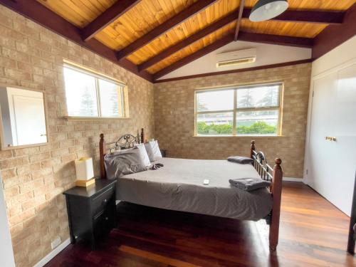 a bedroom with a bed in a brick wall at Esperance Foreshore Apartments in Esperance