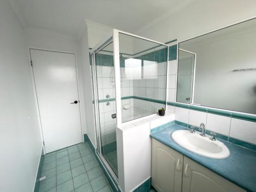 a bathroom with a sink and a mirror at Esperance Foreshore Apartments in Esperance