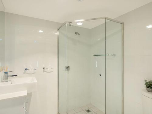 une salle de bain avec une douche en verre et un lavabo dans l'établissement Wharf Apartment Unit 11, à Narooma