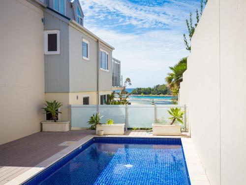 a swimming pool in a house with a view of the ocean at Wharf Apartment Unit 11 in Narooma