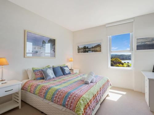 1 dormitorio blanco con 1 cama y 2 ventanas en Wharf Apartment Unit 5 en Narooma