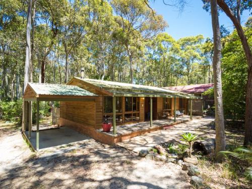 a house in the middle of the forest at Caseys Pet Friendly Beach Cottage in Mystery Bay