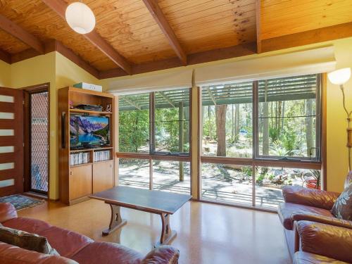 a living room with a couch and a table at Caseys Pet Friendly Beach Cottage in Mystery Bay