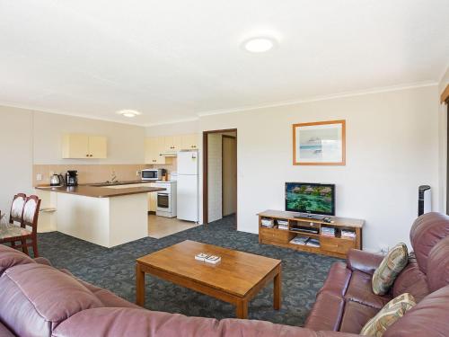 a living room with a couch and a table at Unit 1, 2b Harrington Road in Narooma