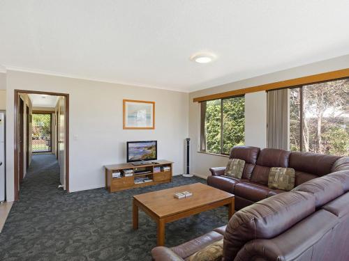 a living room with a couch and a table at Unit 1, 2b Harrington Road in Narooma
