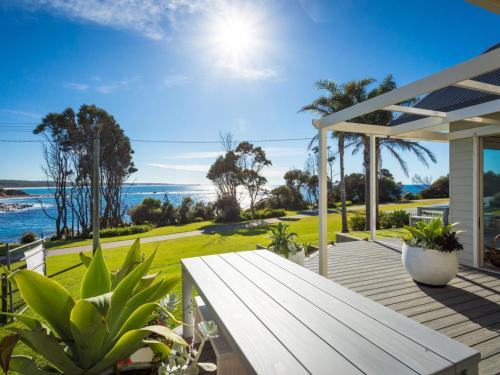 a porch with a bench and a view of the ocean at Dollini Ocean Unit 1 in Dalmeny