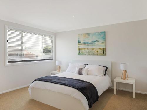 a white bedroom with a large bed and a window at 31 McMillan Crescent, Dalmeny in Dalmeny