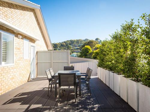 a patio with a table and chairs on a deck at Luxury Beach House in Kianga
