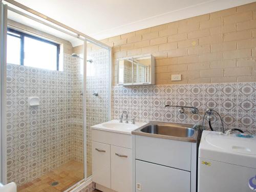 a bathroom with a sink and a shower at Apollo Unit 12 Ground Floor in Narooma