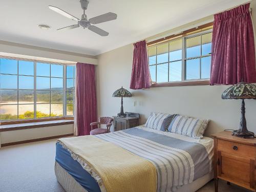 a bedroom with a bed and a large window at 120 Ocean Parade Dalmeny in Dalmeny