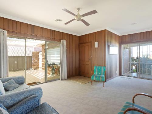 a living room with a couch and a ceiling fan at 120 Ocean Parade Dalmeny in Dalmeny