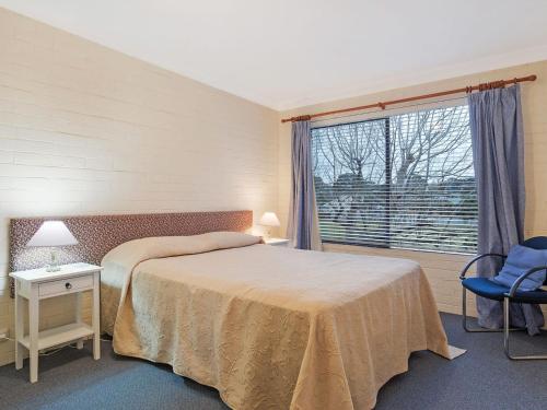 a bedroom with a bed and a large window at Apollo Unit 23 First Floor in Narooma