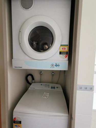 a washing machine sitting on top of a washer at The Anchorage Apartments in Mount Maunganui