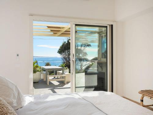 
a bedroom with a bed and a window at Dollini Ocean (Unit 1) in Dalmeny
