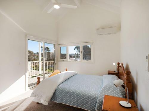 a bedroom with a blue bed and a window at Dollini Ocean Unit 1 in Dalmeny