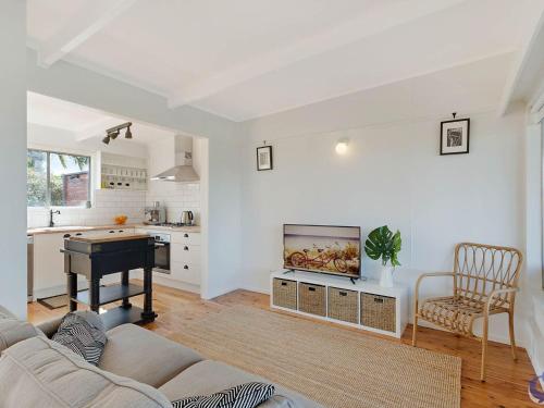 a living room with a couch and a tv and a table at House One at Potato Point in Potato Point