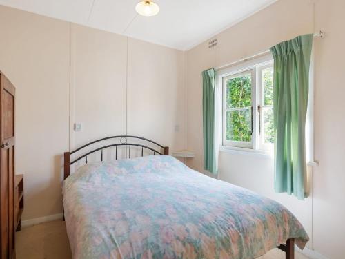 a bedroom with a bed and a window at Pet Friendly Beach Cottage @ Ballingalla in Narooma